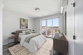 A bedroom with a large bed and a view of the outside.