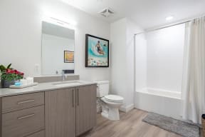 Bathroom with storage and tiled tub at The Chandler in North Hollywood