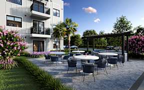 A modern building with a patio and chairs.