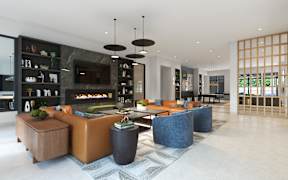 A modern living room with a fireplace and a variety of seating options.