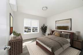 A bedroom with a large bed and a window overlooking a snowy landscape.