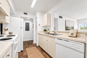 A kitchen with white appliances and wooden cabinets.