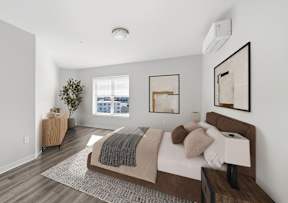 A bedroom with a large bed and a window overlooking a cityscape.