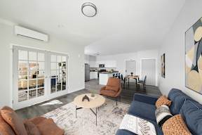 A living room with a couch, chairs, and a rug.
