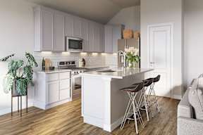 A modern kitchen with white cabinets and a wooden floor at Walker Place Apartments, Hewitt, Texas