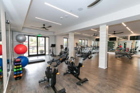 a spacious gym with cardio equipment and a variety of exercise balls