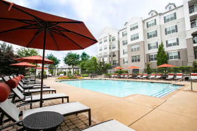 Pool with loungers and umbrellas | Emblem Alpharetta