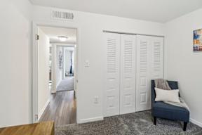 a living room with white doors and a blue chair at Oaks at Oxon Hill, Oxon Hill, Maryland
