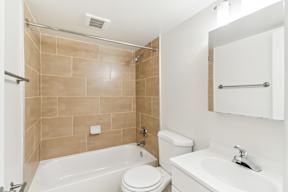 a bathroom with a toilet sink and tub and a mirror at Oaks at Oxon Hill, Oxon Hill, Maryland