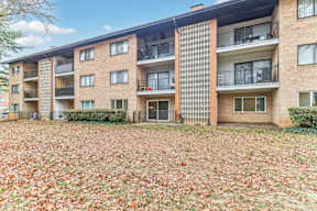 an exterior view of an apartment building with fallen leaves at Oaks at Oxon Hill, Oxon Hill, Maryland