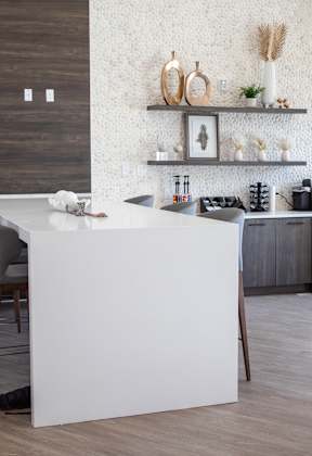 A kitchen with white countertops and a white island