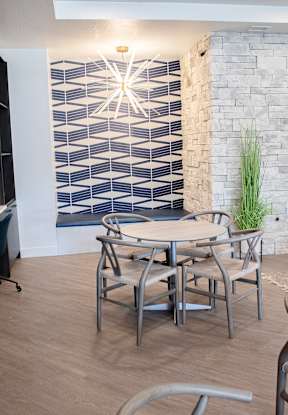 A table and chairs in front of a brick wall