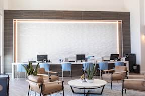 A room filled with furniture and a large white brick wall