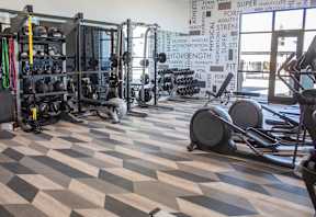 A fitness room with a checkered floor and weights