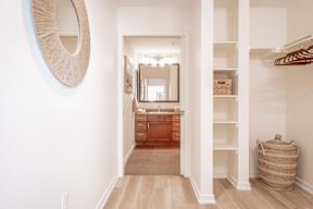 A hallway with a mirror and a wicker basket on the floor.