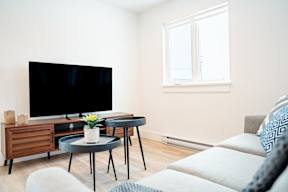 A living room with a television, a table, and a couch.