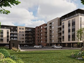 A modern apartment complex with a parking lot in front.
