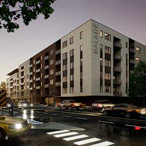 A modern building named Balade is depicted with cars passing by on the street in front of it.