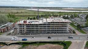 A large building under construction is seen from an aerial perspective.