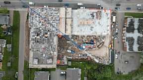An aerial view of a construction site with a crane and a building under construction.