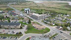 A large building is under construction in the middle of a parking lot.