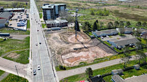 A road with cars on it and a building in the background.