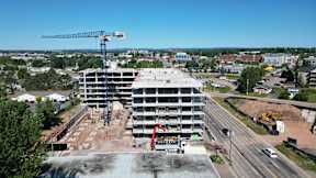 A large building under construction with a crane in the background.
