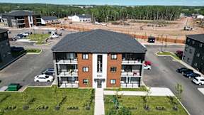 an aerial view of an apartment building with a parking lot