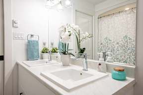 a white bathroom with two sinks and a mirror