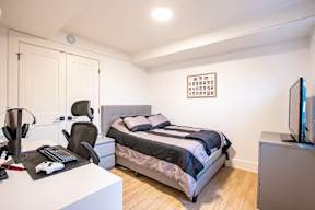 a bedroom with a bed and a desk and a tv