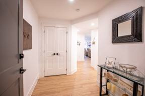 a hallway with a white door and a glass table