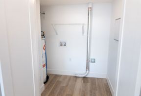 A white room with a pipe running along the wall.