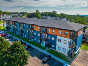 an aerial view of an apartment building in a parking lot