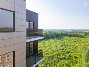 a view of the forest from the balcony of a modern building
