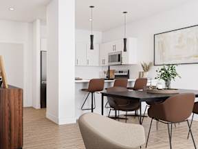 A modern kitchen with a dining table and chairs.