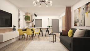 An open floor plan kitchen and living room. The space has a curtain that can divide the kitchen from the living room. The kitchen contains a bar and a walk-in pantry. The living room has a flatscreen television above an entertainment center opposite a two-person couch.