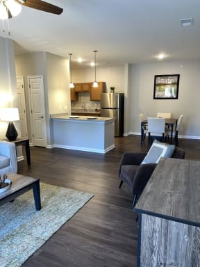 a view of a living room and a kitchen with a table and chairs
