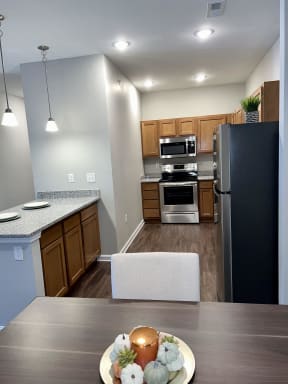 a kitchen with stainless steel appliances and a table with a cake
