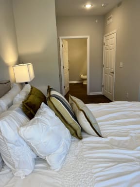 a bedroom with a large bed with white sheets and pillows