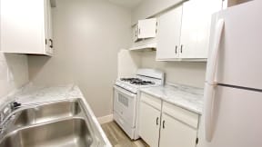 a kitchen with white cabinets and white appliances