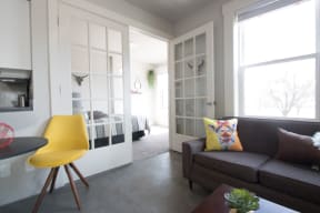 a small living room with a couch and a yellow chair