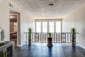 a living room with a balcony and a table with plants