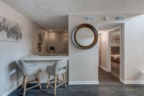 a kitchen with stools and a counter with a mirror