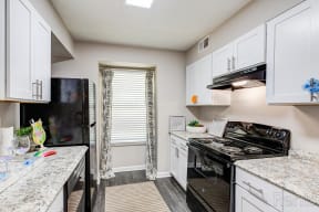 a kitchen with white cabinets and black appliances