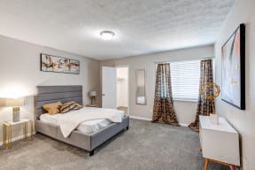 a bedroom with a bed and a window with curtains