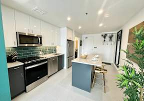 A kitchen with a black stove top oven and a black microwave.