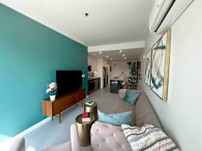 A living room with a grey couch and a wooden entertainment center.
