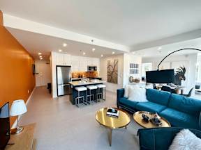 A modern living room with a blue couch and a gold coffee table.