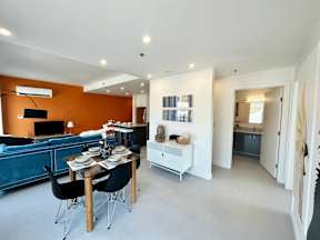 A modern living room with a dining table set for two.