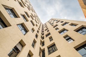an upward view of a large tan building with windows